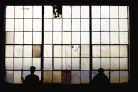 silhouette of people standing near window