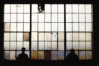 silhouette of people standing near window