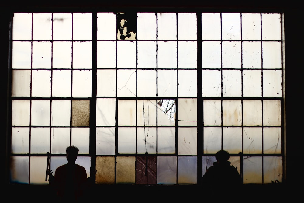 silhouette of people standing near window