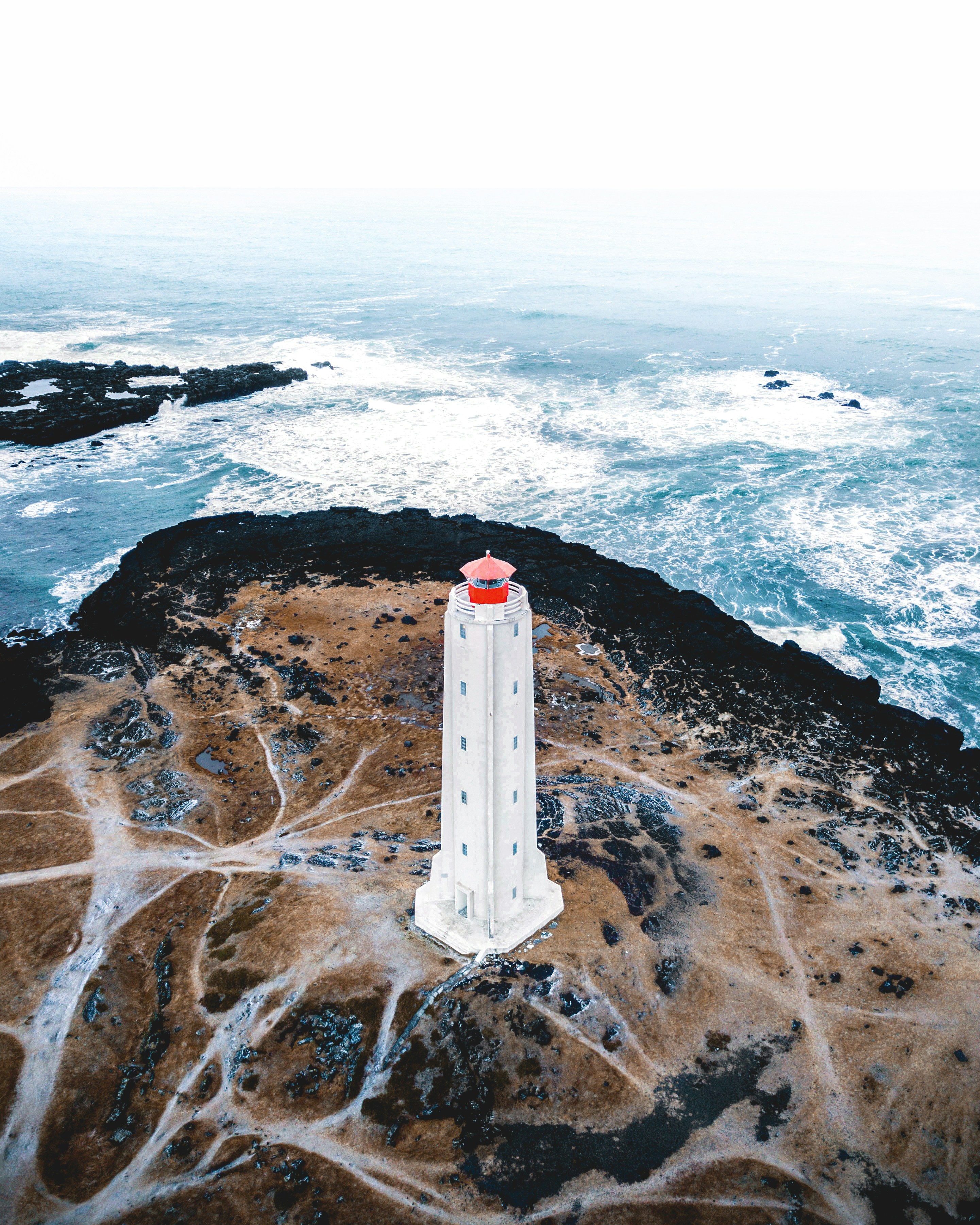 bird's eye photography of white lighthouse tower near ocean