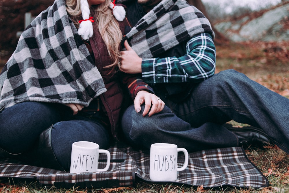 two person cuddling on gray plaid mat