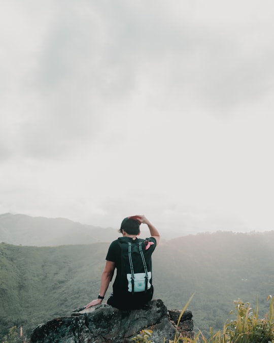 man sitting on rock and facing on mountain in Tanay Philippines