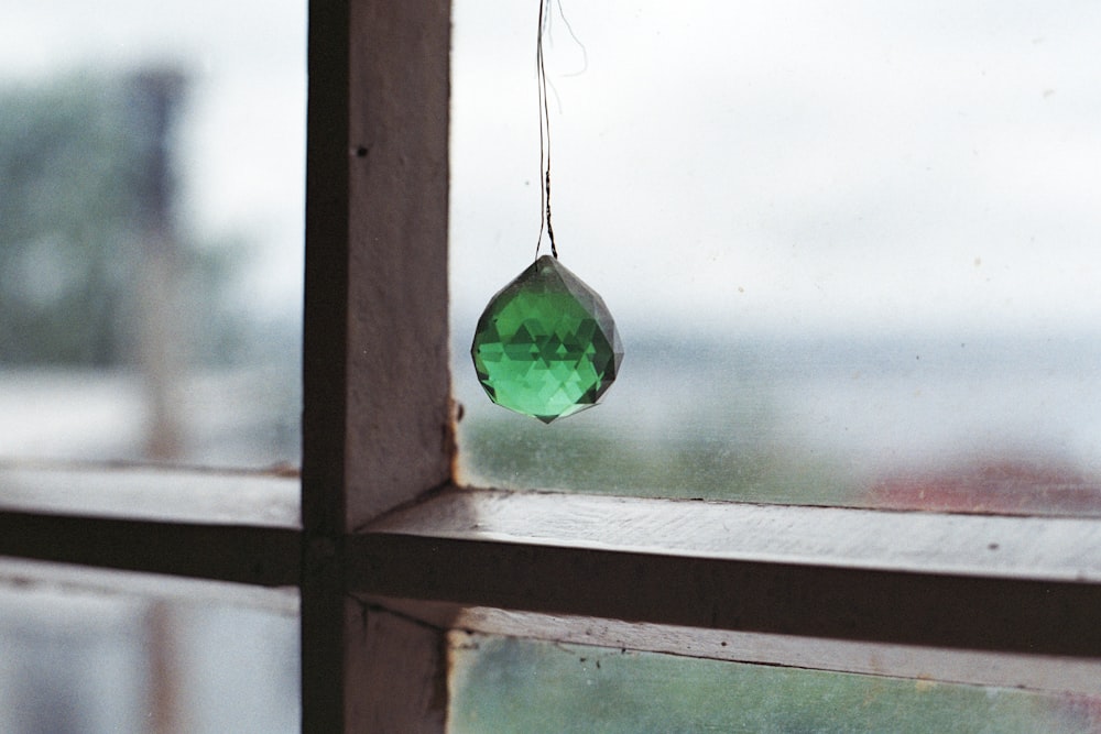 photo of hanging green stone near window