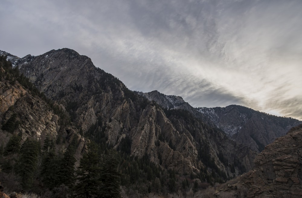 rugged mountain under white cloud blue skies