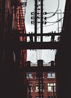 brown electric post near building at daytime