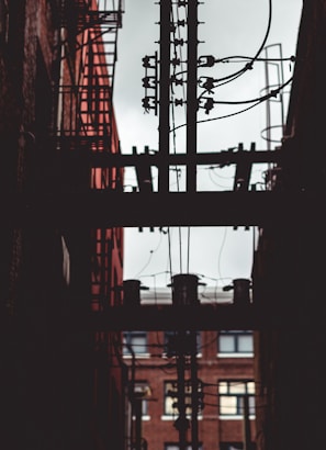 brown electric post near building at daytime