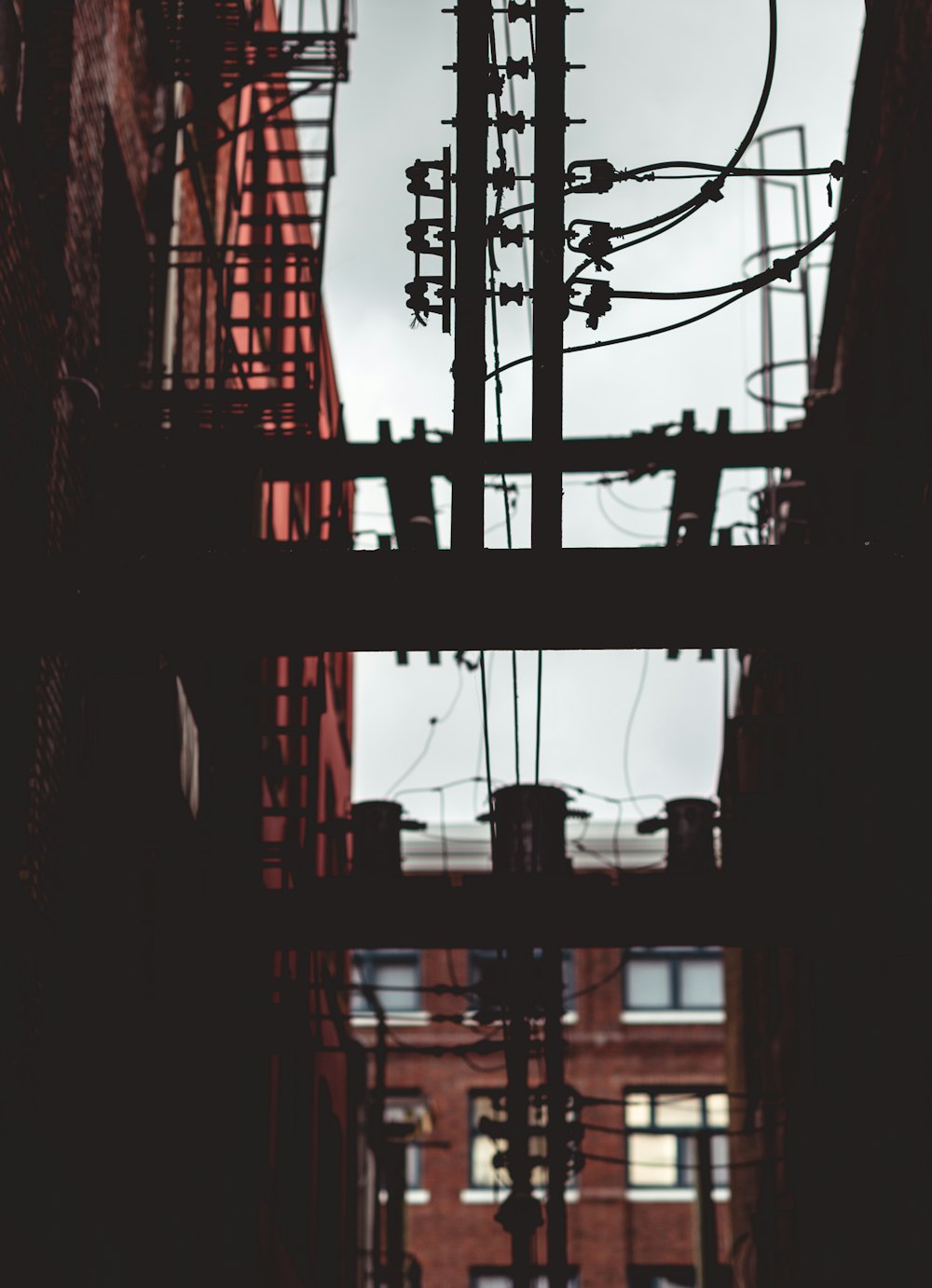 brown electric post near building at daytime