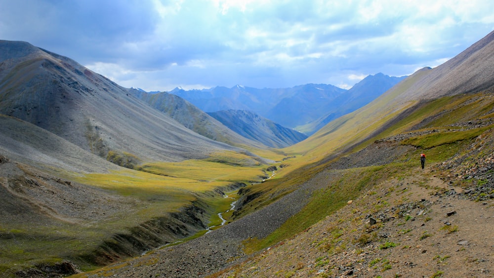 brown mountains view under blue cloudy sky