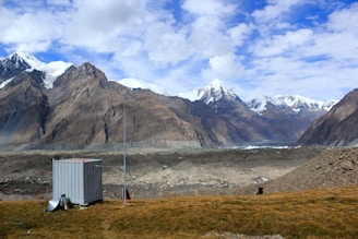 A rugged mountain landscape with a ham radio setup perched on a rocky outcrop.