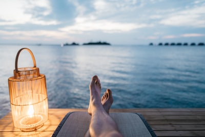 person lying on chair and facing on body of water chill zoom background