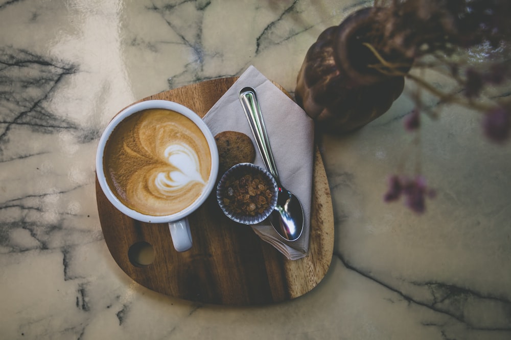 spoon near coffee cup and brown vase