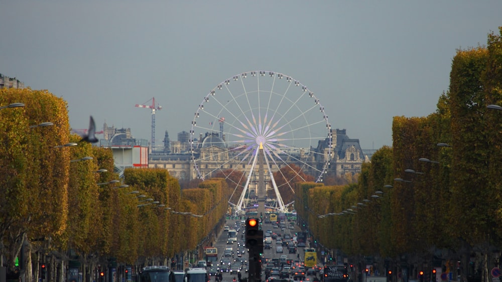 white ferris wheel in the middle of concrete road at daytime