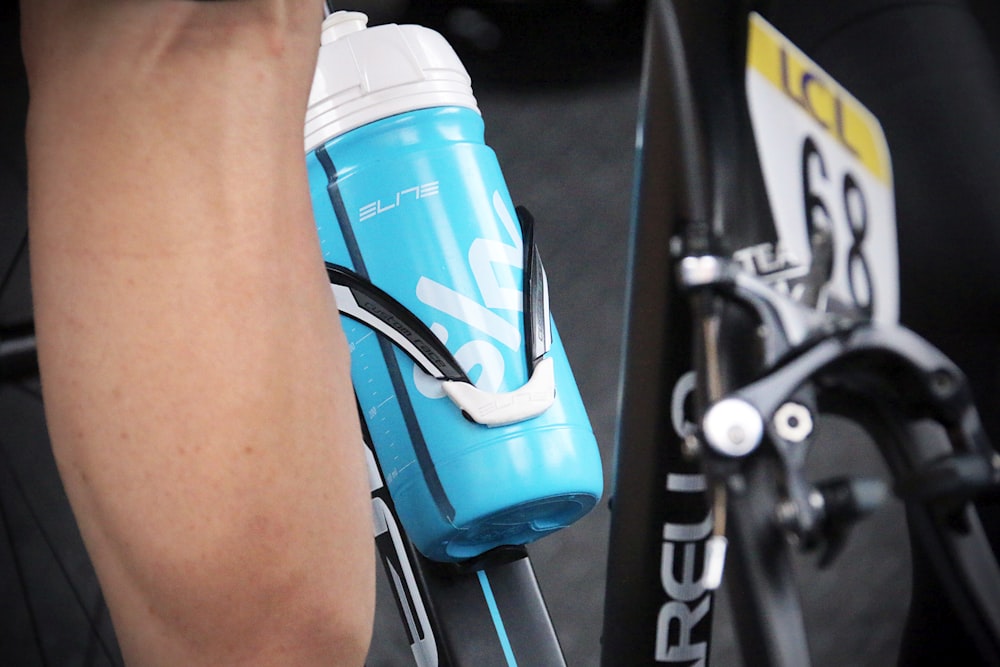 blue and white Elite sports bottle on gray bike rack