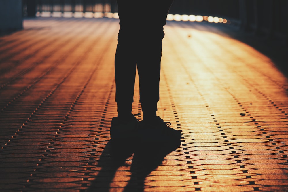 silhouette of man standing on concrete pavement