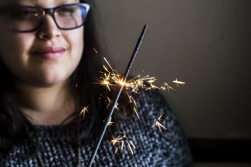 focus photography of woman holding sparkler