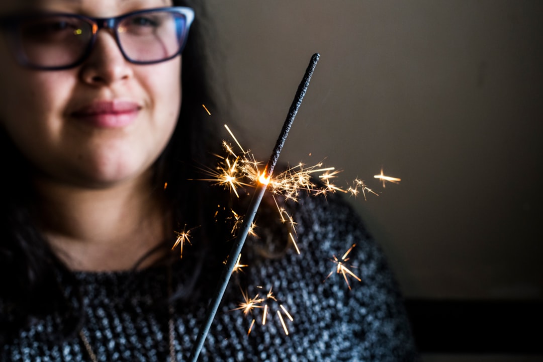focus photography of woman holding sparkler