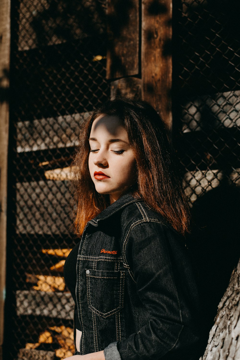 shallow focus photography of woman leaning on fence