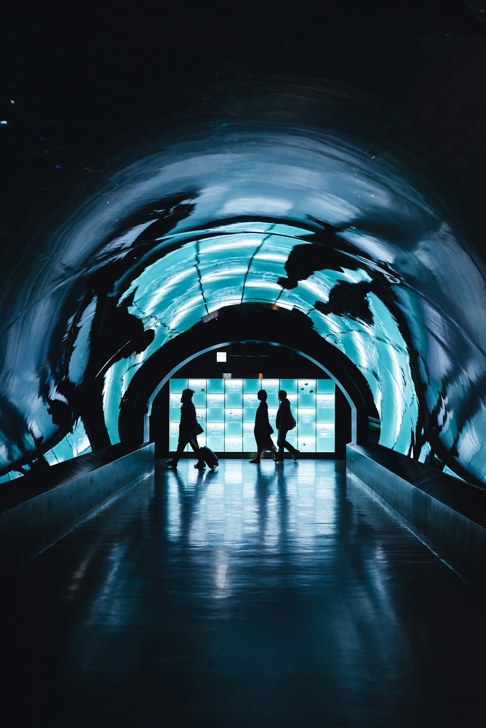 silhouette di tre persone che camminano vicino al tunnel