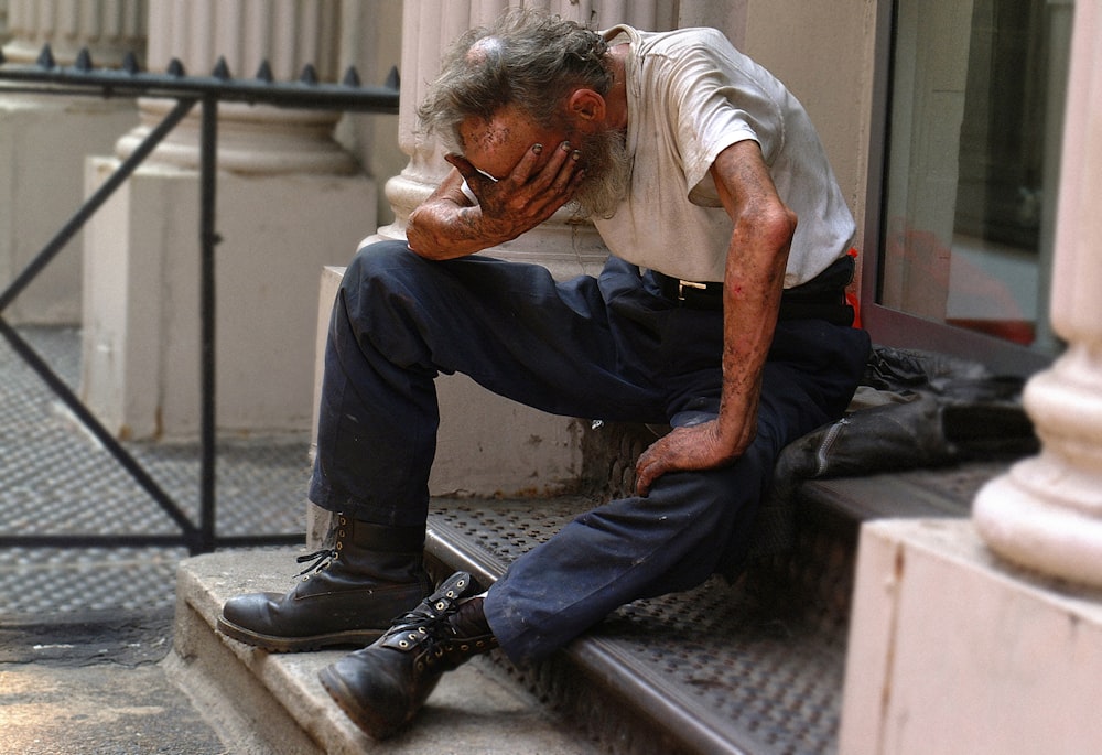 a man sitting on a step with his head in his hands