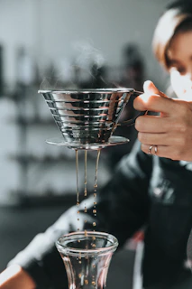 person holding gray stainless steel cup with smoke