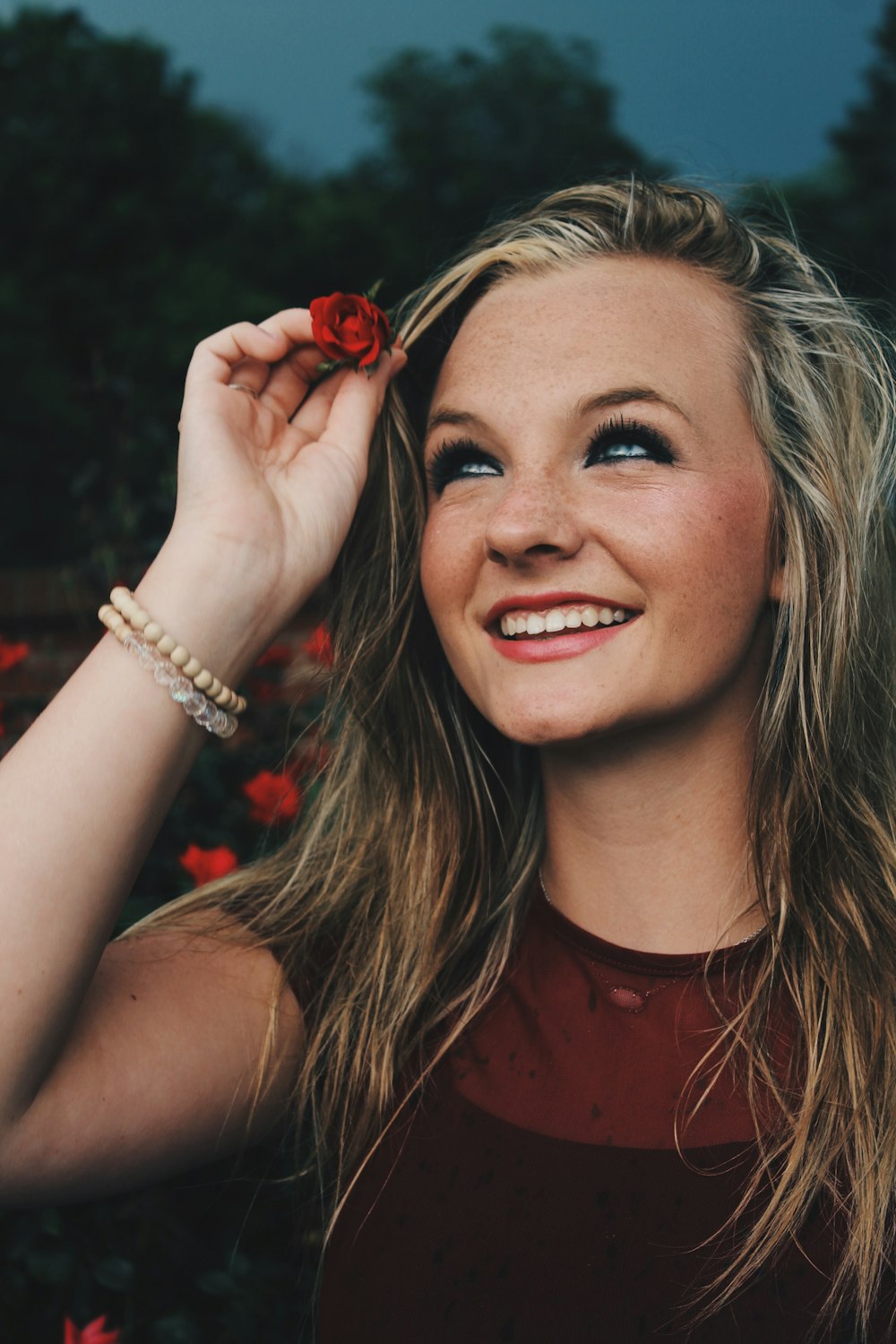 woman holding red flower