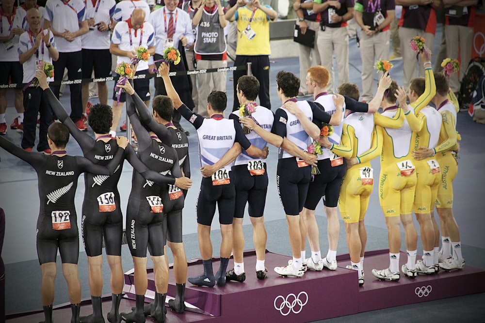 group of men standing in podium holding flowers