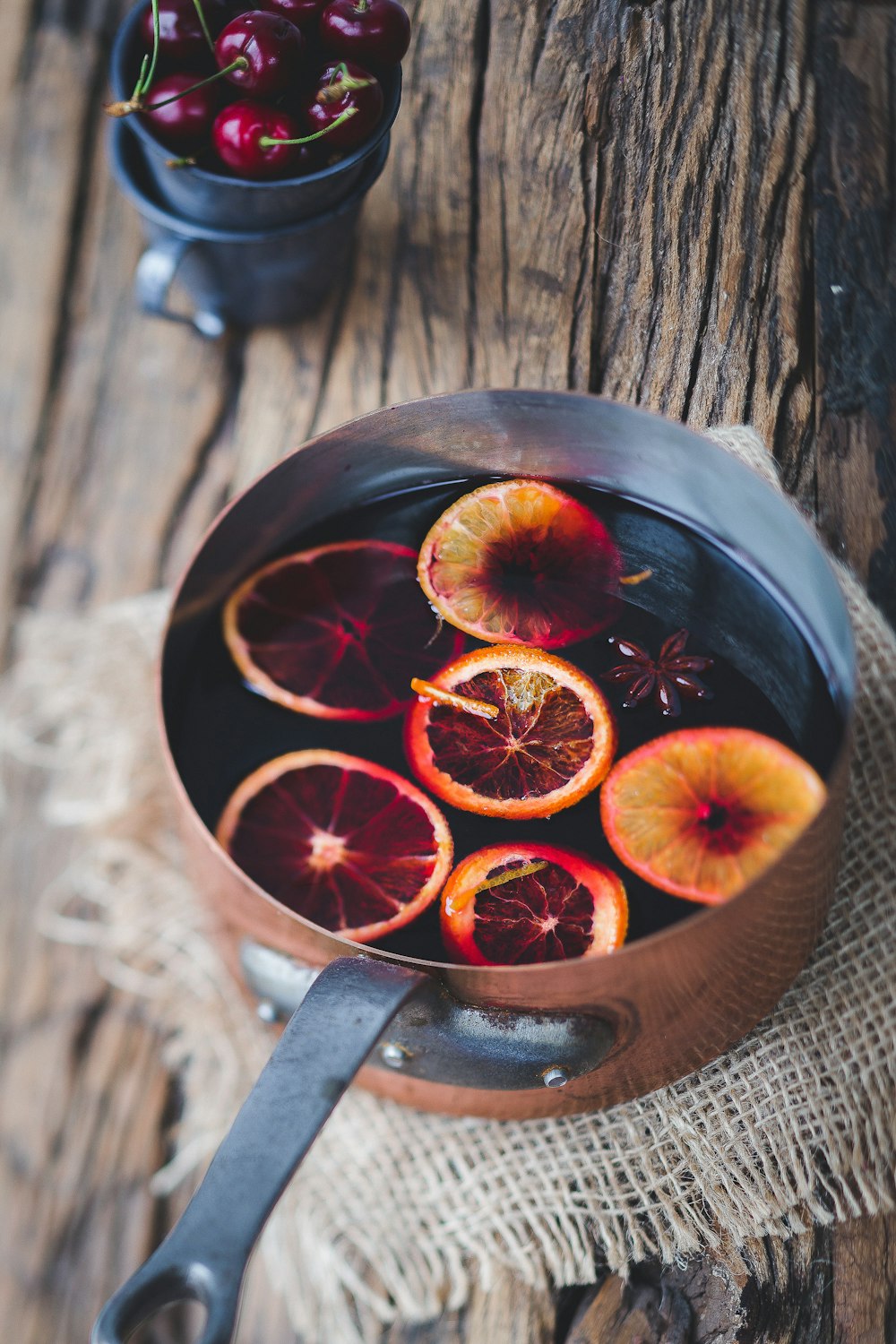 Nahaufnahme von geschnittenen orangefarbenen Früchten auf braunem Kochtopf