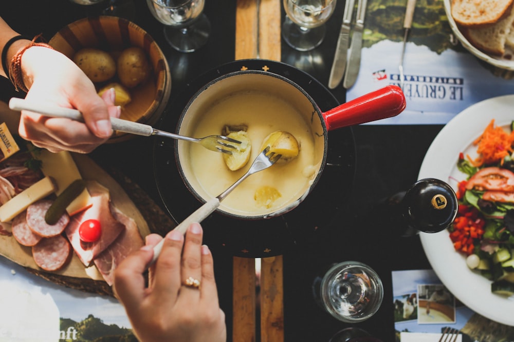 people dipping bread in fondu pot