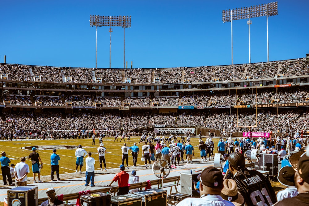 group of people watching football game during daytime