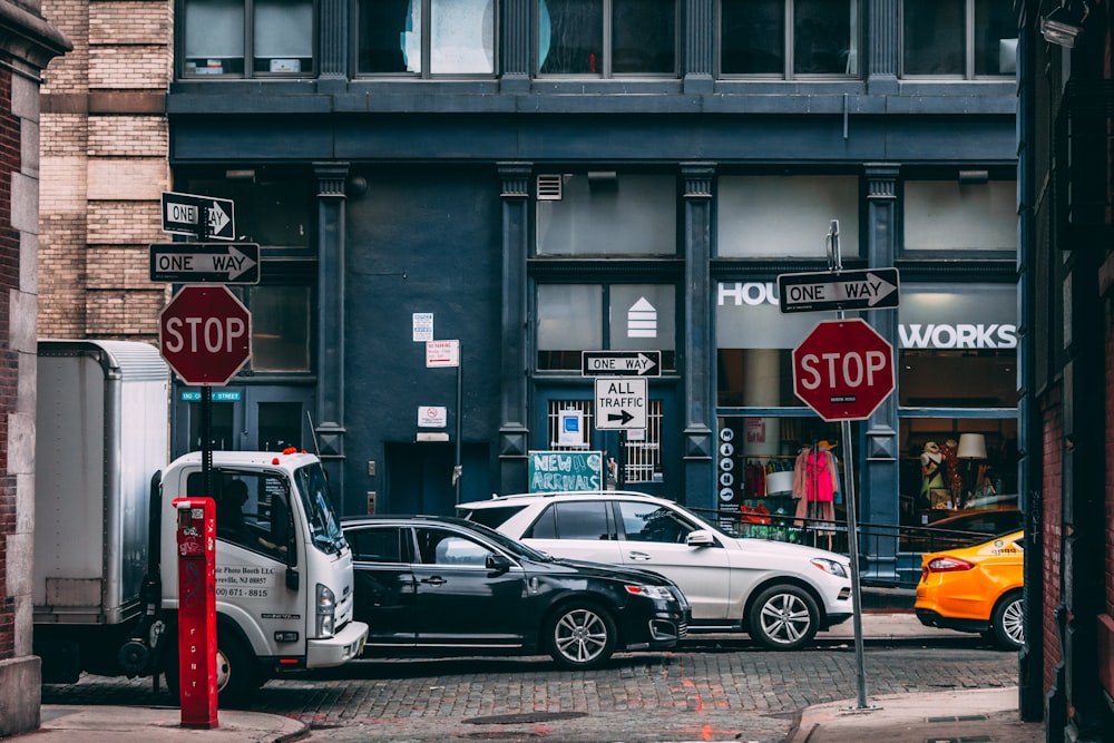 Varios vehículos estacionados cerca de dos señales de alto