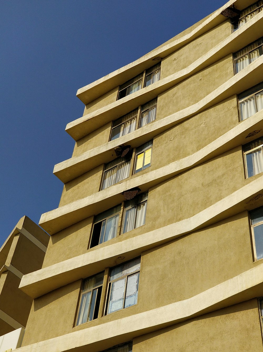 brown high-rise building under clear blue sky during daytime