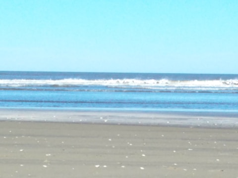 A tranquil beach scene with clear blue waters.
