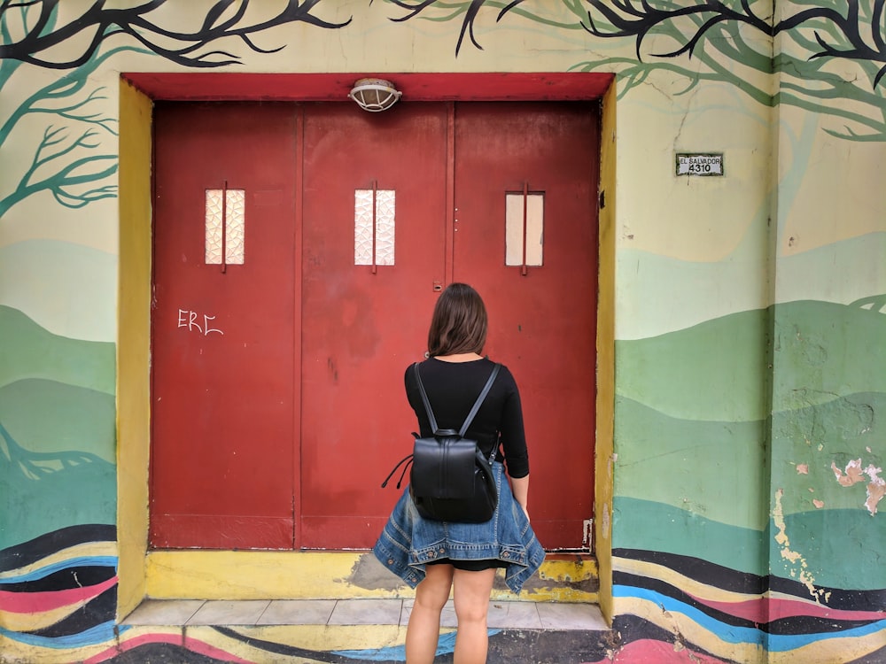 woman facing wooden door