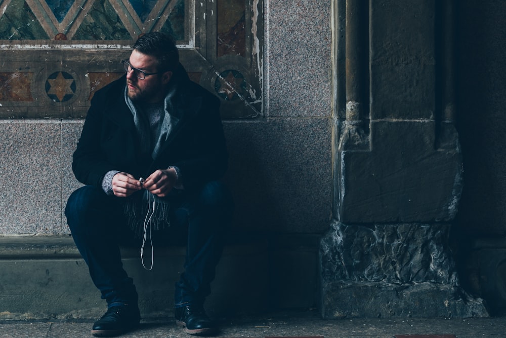 man sitting on pavement on vignette photography