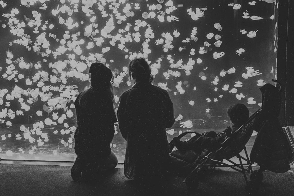 grayscale photography of couple with child in stroller