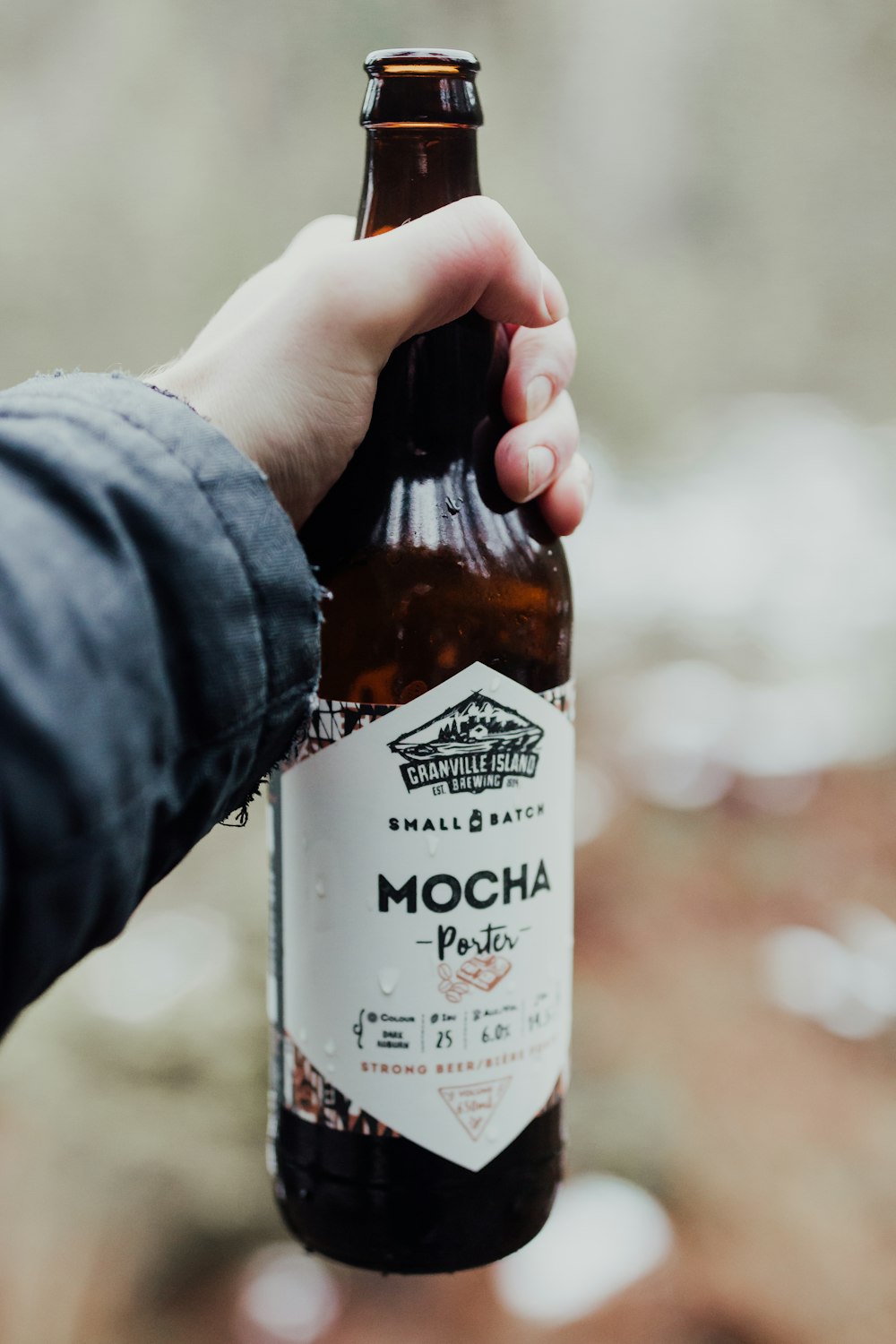 person holding Mocha porter beer bottle