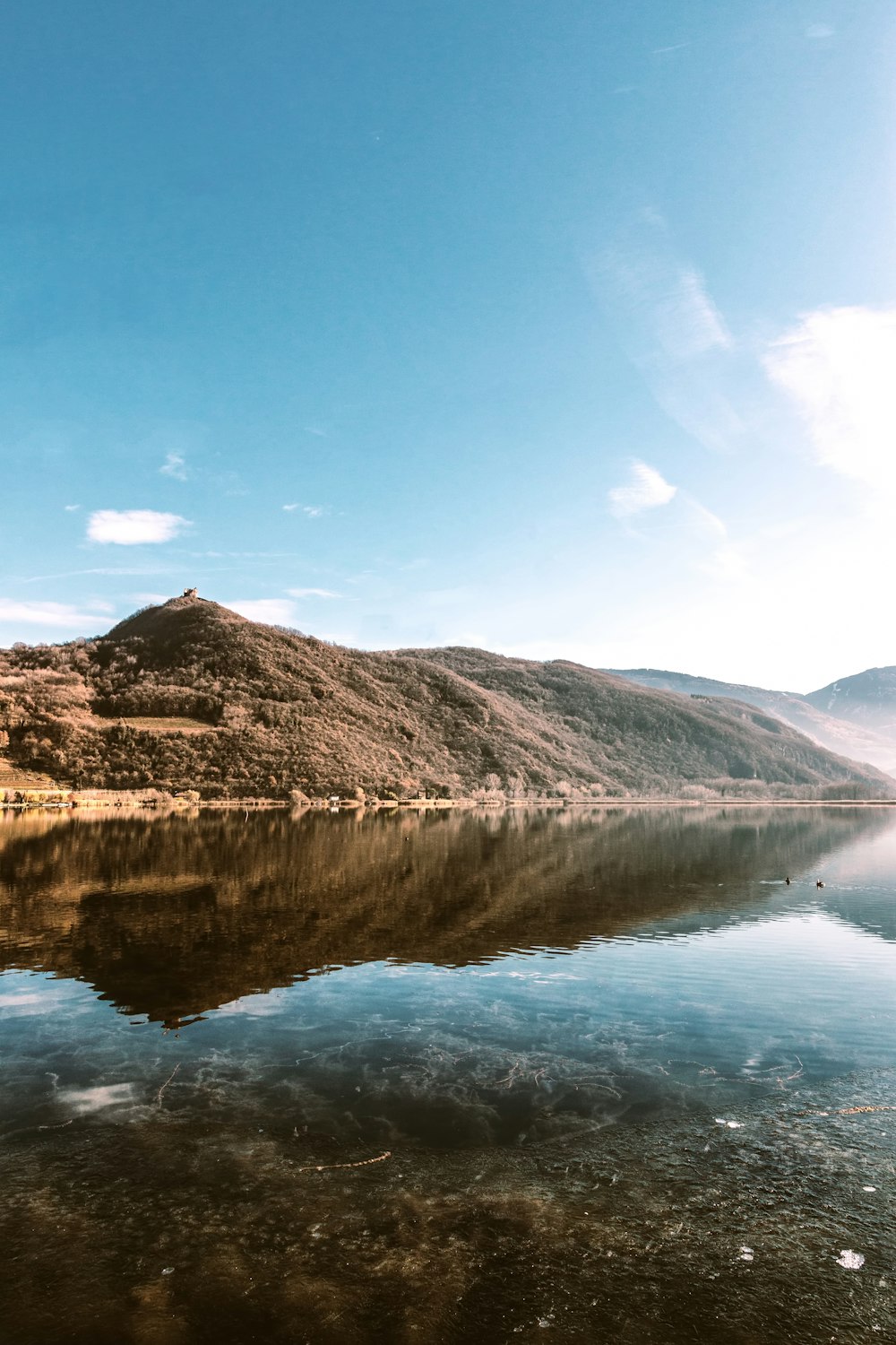 body of water across brown hills