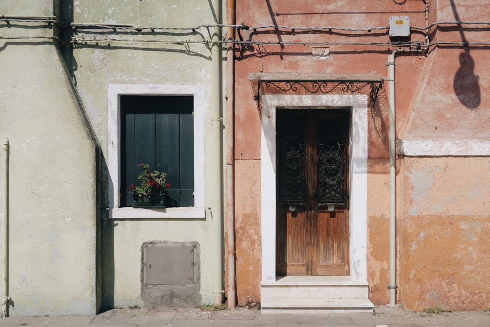 closed door and window of red and white building at daytime