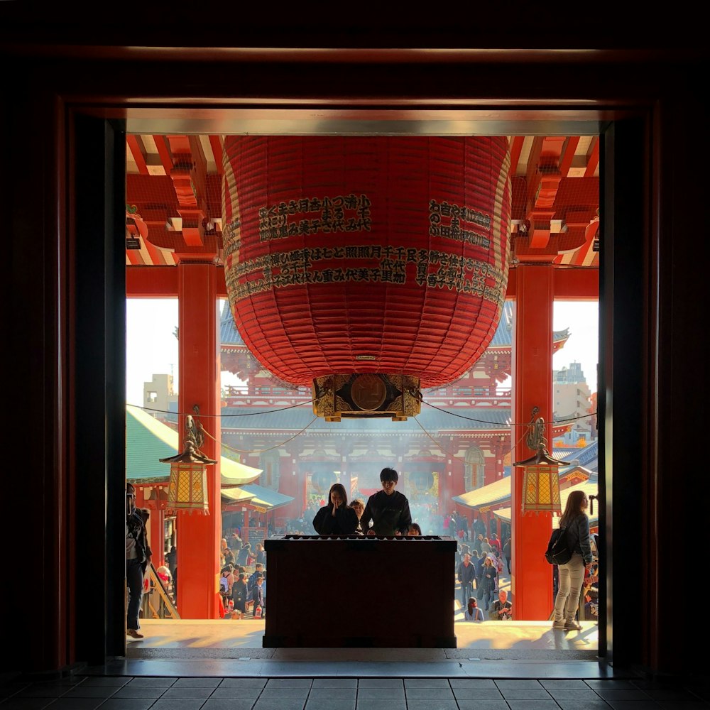 two person standing on altar praying inside temple