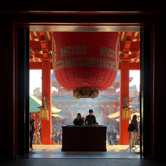 two person standing on altar praying inside temple in Sensō-ji Japan