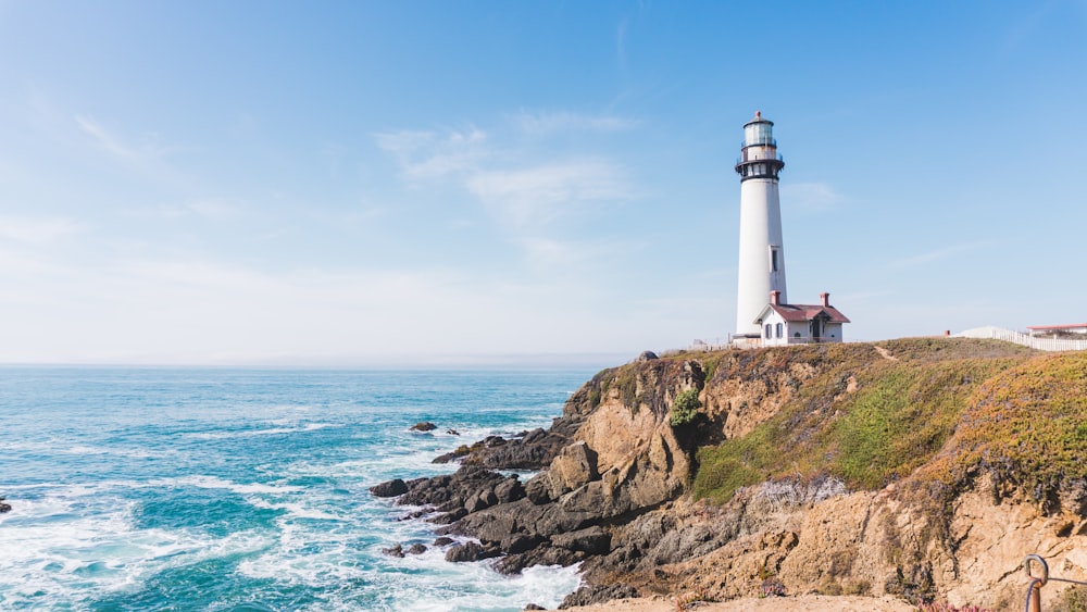 lighthouse in mountain next to ocean