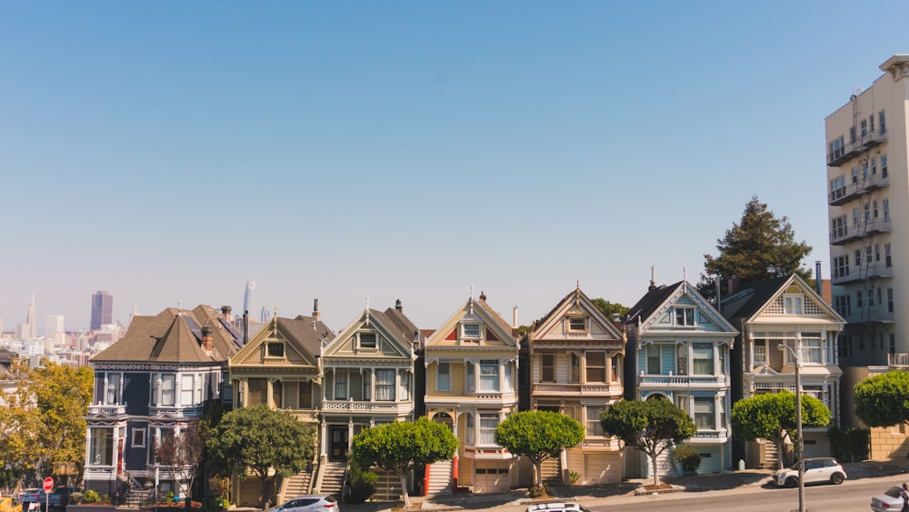 houses beside trees under clear blue sky during daytime