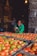 Photo of a smiling customer holding a crate of tomato paste cans in a warehouse.