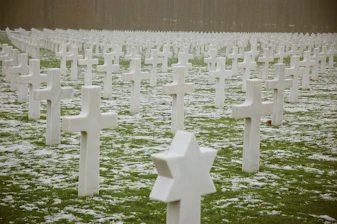 white concrete cross tomb on green grass field