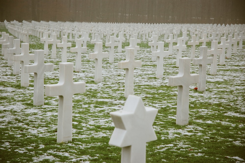 white concrete cross tomb on green grass field