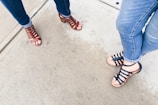 two woman wearing black and brown strappy sandals