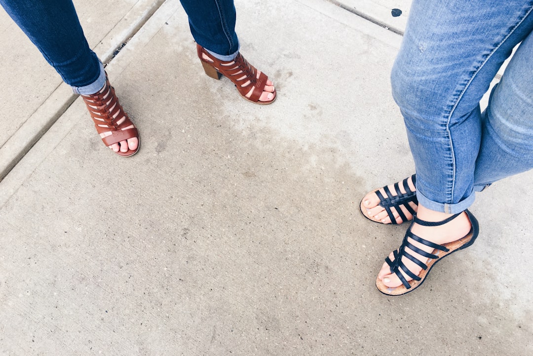 two woman wearing black and brown strappy sandals, Cuffed Jeans and Gladiator Sandals