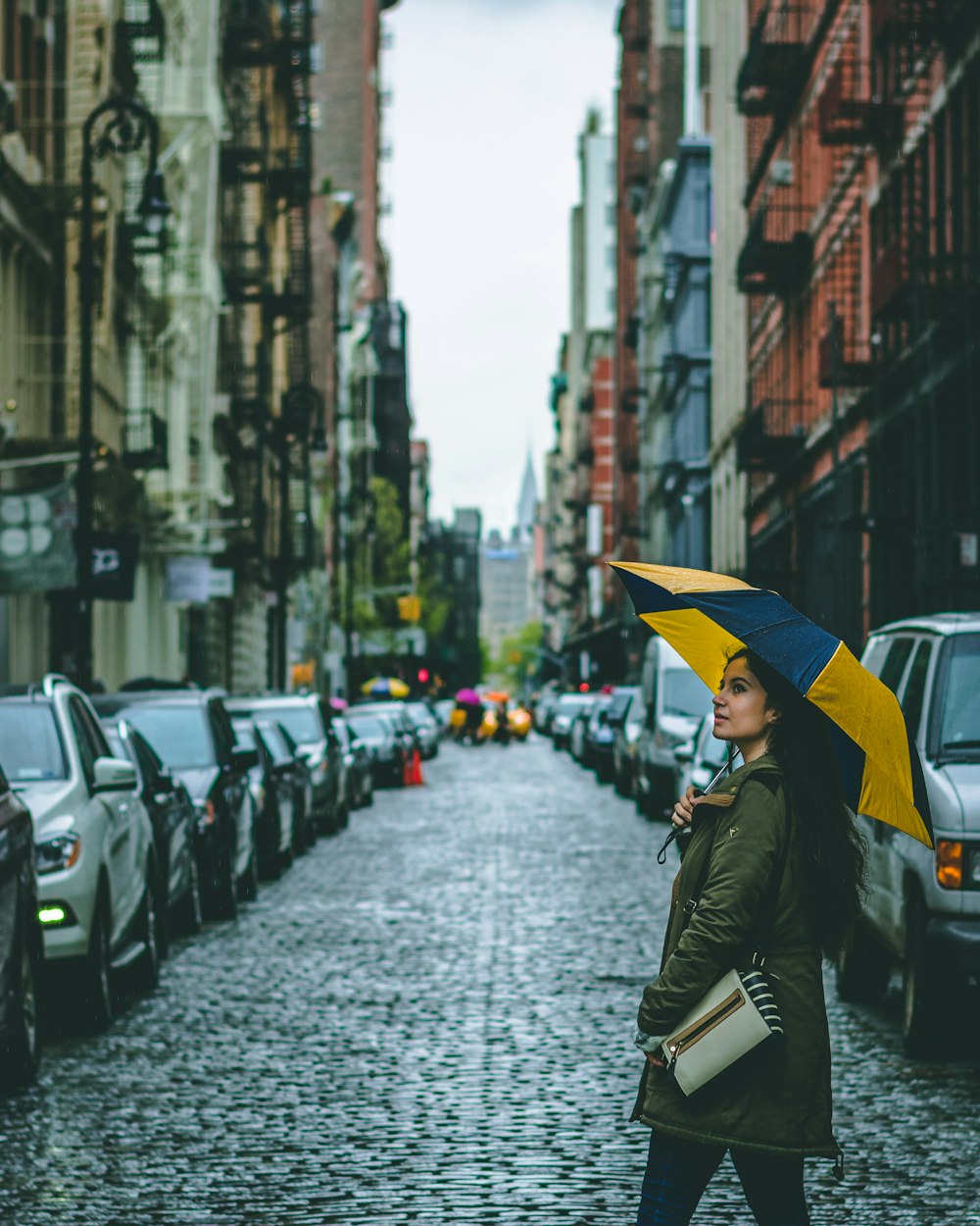 woman holding umbrella surrounded by cars