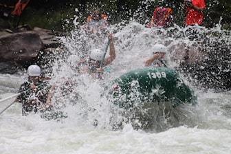 Group of tourists rafting down Ayung River in Ubud surrounded by lush jungle and cascading waterfall