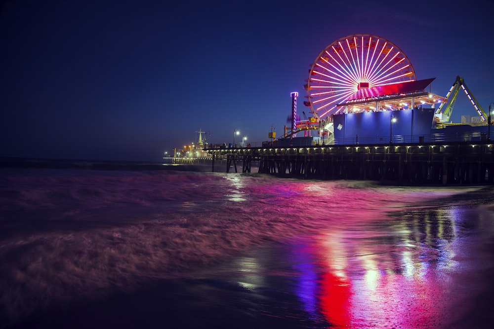 Photo d’une grande roue près d’un plan d’eau pendant la nuit